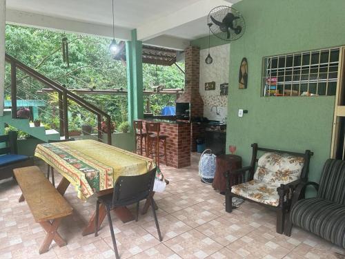 ein Wohnzimmer mit einem Tisch und Stühlen in einem Zimmer in der Unterkunft casa indisponivel in Caraguatatuba