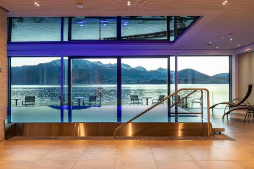 a house with a swimming pool with a view of the water at Seegasthof Hois'n Wirt - Hotel mit Wellnessbereich in Gmunden