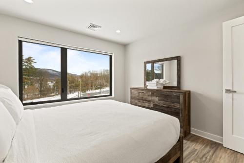 a bedroom with a bed and a large window at Upstate NY Lake House in Lake George