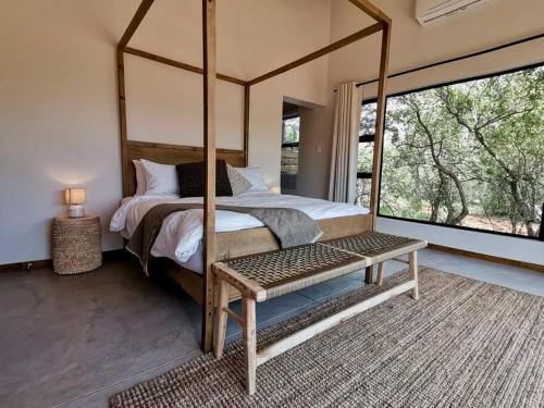a bedroom with a canopy bed and a window at Corkwood Villa in Hoedspruit
