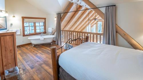 a bathroom with a bed and a tub in a room at Snow Creek Cabins by Fernie Lodging Co in Fernie