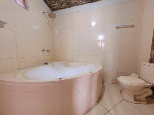 La salle de bains est pourvue d'une baignoire blanche et de toilettes. dans l'établissement Illari Wari II-Hotel Sauna, à Ayacucho