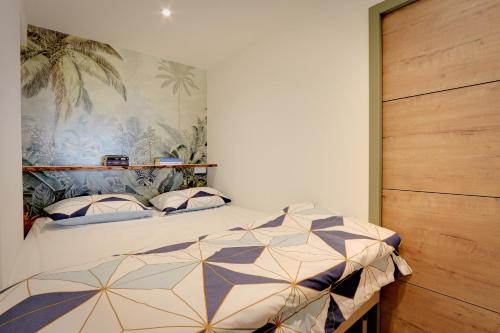 Schlafzimmer mit einem Bett mit Wandgemälde in der Unterkunft Appartement cosy climatisé à 100m des plages in Gassin