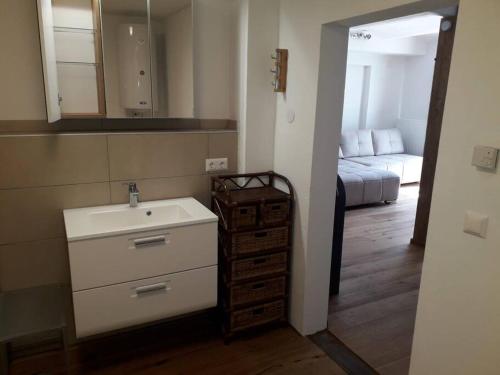 a bathroom with a sink and a room with a bed at LOFT im Erdgeschoss, 45m², Kreuzbergl (1-3 Gäste) in Klagenfurt