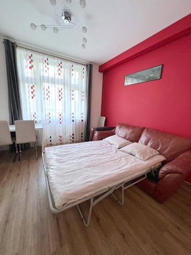 sypialnia z kanapą i czerwoną ścianą w obiekcie Bohemian Apartments near the Center w Pradze