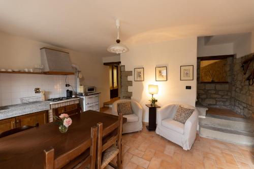 cocina y sala de estar con mesa y sillas en Borgo di Porciano Casa Elisabetta en Stia