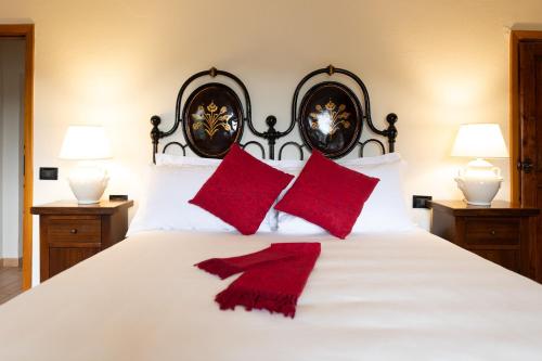 a bedroom with a white bed with red pillows at Borgo di Porciano Casa Elisabetta in Stia