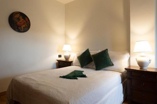 a bedroom with a white bed with two lamps at Borgo di Porciano Casa Elisabetta in Stia