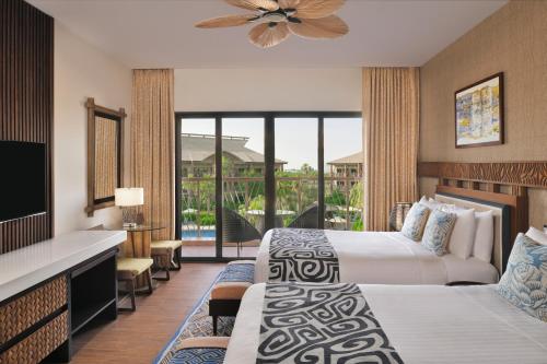 a hotel room with two beds and a balcony at Lapita, Dubai Parks and Resorts, Autograph Collection in Dubai