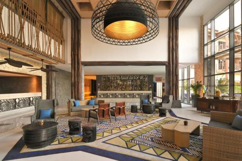 a lobby with couches and chairs and a table at Lapita, Dubai Parks and Resorts, Autograph Collection in Dubai