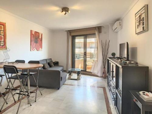 een woonkamer met een bank en een tafel bij Apartamento Manilva con terraza y piscina in Manilva
