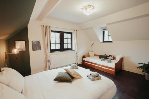 a bedroom with two beds and two windows at L'Ecluse Simon in Tilff