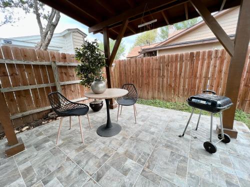 a patio with a table and chairs and a grill at Modern 2 bedroom house w/backyard @La Cantera in San Antonio