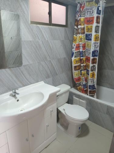 uma casa de banho com um lavatório, um WC e um espelho. em Departamentoswilson em Iquique
