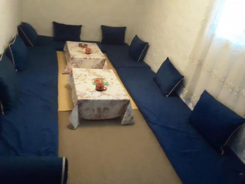 Pokój ze stołem i niebieskimi poduszkami w obiekcie Casa de campo w mieście Al-Husajma