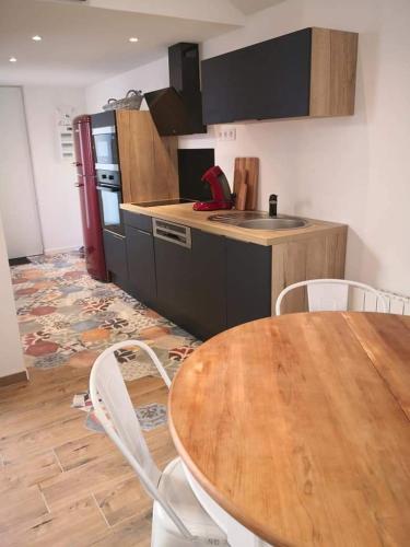 une cuisine avec une table en bois et une table et des chaises dans l'établissement cottage du Fort Ambleteuse, à Ambleteuse