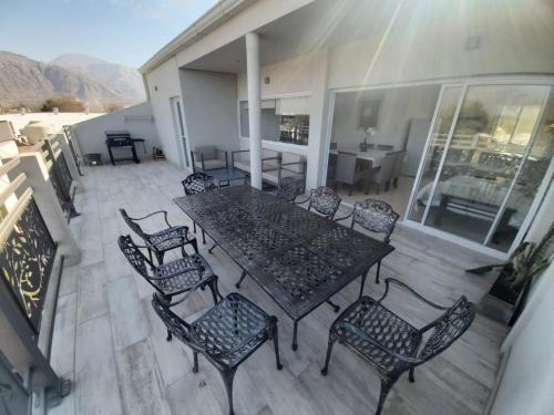 eine Terrasse mit einem Tisch und Stühlen auf dem Balkon in der Unterkunft Departamento en los Valles in Cafayate