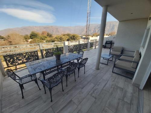 patio con mesa y sillas en el balcón en Departamento en los Valles en Cafayate