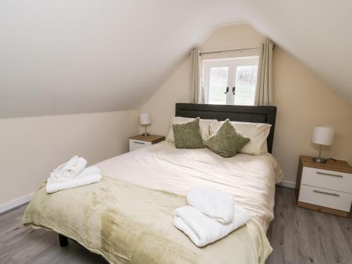 a bedroom with a bed with towels on it at Railway Station Cottage in Llandrindod Wells