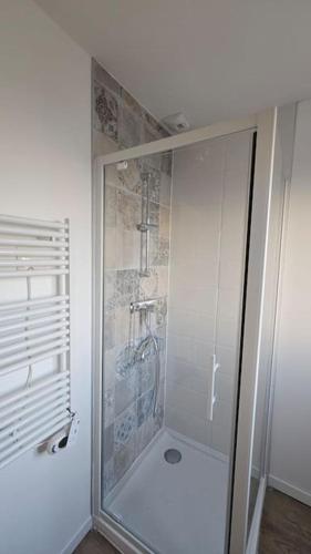 a shower with a glass door in a bathroom at Nid douillet en Suisse Normande in Thury-Harcourt