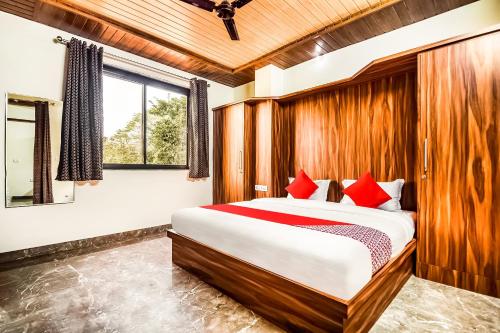 a bedroom with a large bed with red pillows at Eleven Suites in Kota
