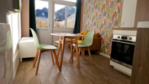 una mesa y sillas en una cocina con ventana en Nid douillet en Suisse Normande, en Thury-Harcourt