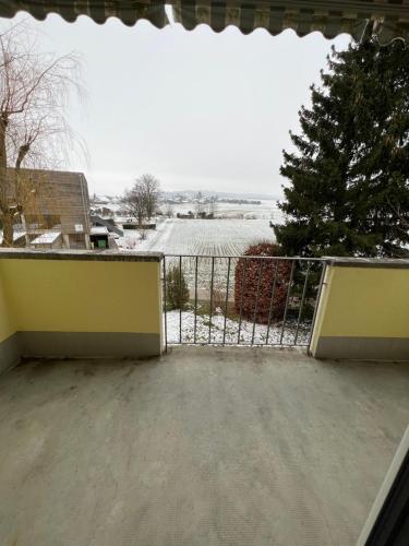 ein Tor auf einem Balkon mit einem schneebedeckten Hof in der Unterkunft 3 Zimmer Wochnungsvermitung in Orpund -Biel in Orpund
