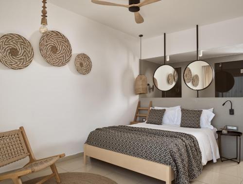 a bedroom with a bed and mirrors on the wall at Seaside A Lifestyle Resort - Adults Only in Agia Pelagia