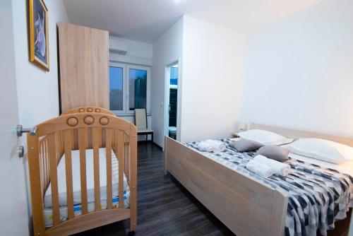- une chambre avec un lit et un fauteuil en bois dans l'établissement Holiday villa Sara, à Košute