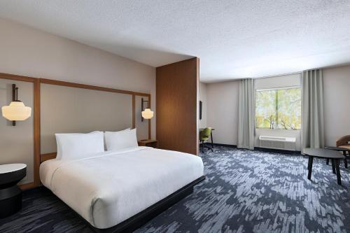 a hotel room with a bed and a window at Fairfield by Marriott Inn & Suites Hillsboro in Hillsboro