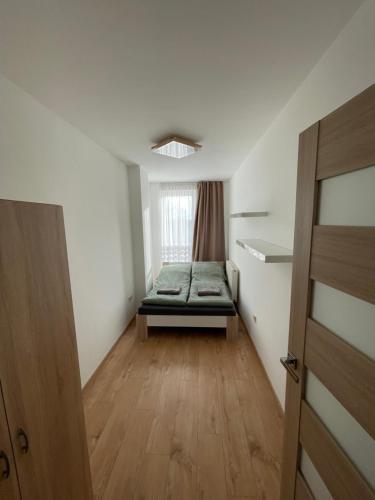 een kleine kamer met een bed in het midden bij Sarló Apartman in Debrecen