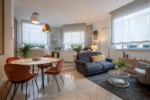 cocina y sala de estar con mesa y sillas en TRENTINO LODGE Piazza Municipio, en Strigno