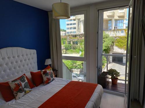 um quarto com uma cama e uma grande janela em Departamento Playa 3 em Mar del Plata
