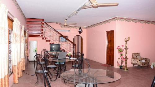 a room with a table and chairs and a staircase at New AT hotel in Jaffna