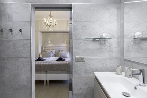 une salle de bain avec un lit, un lavabo et un miroir dans l'établissement Appartement De Luxe, Meynadier by Halldis, à Cannes