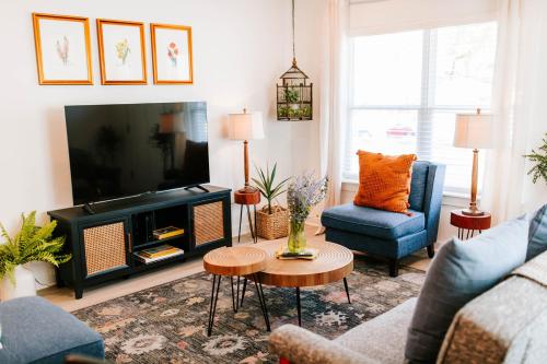 a living room with a tv and a couch and a table at Artist Retreat Near Downtown, Stadium & UGA in Athens