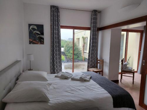 une chambre avec un grand lit et une grande fenêtre dans l'établissement BRETAGNE - La Villa Littorine, à Ploemeur