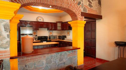 una cocina con armarios de madera y un arco en Palacio del conquistador, en San Cristóbal El Bajo