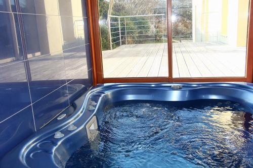 une baignoire bleue avec une fenêtre dans une maison dans l'établissement BRETAGNE - La Villa Littorine, à Ploemeur