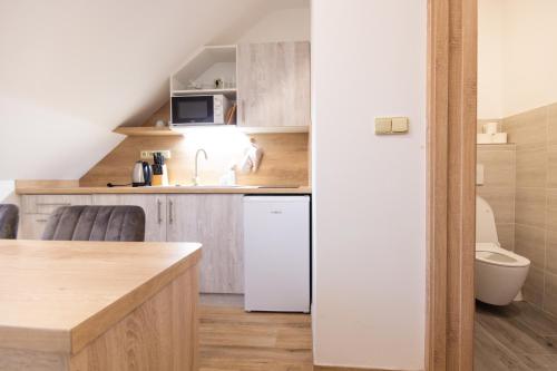 a small kitchen with a sink and a white refrigerator at Penzion pod Kozákem in Mikulov