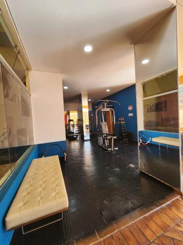 a gym with a bench in the middle of a room at Edifício Belluno in Ribeirão Preto