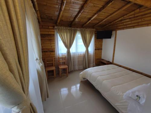 a bedroom with a large bed and a window at De Bambú Guatavita in Guatavita