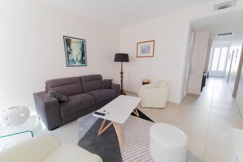 un salon avec un canapé et une table dans l'établissement Alceste Apartment - Cannes Banane, à Cannes