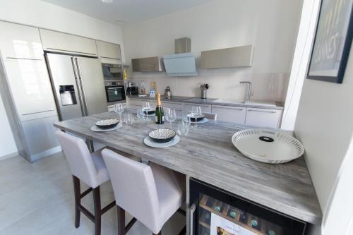 une cuisine avec une grande table en bois et des chaises dans l'établissement Alceste Apartment - Cannes Banane, à Cannes