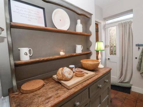 a kitchen with a counter with bread and plates on it at Rosemary Cottage, Aldeburgh in Aldeburgh
