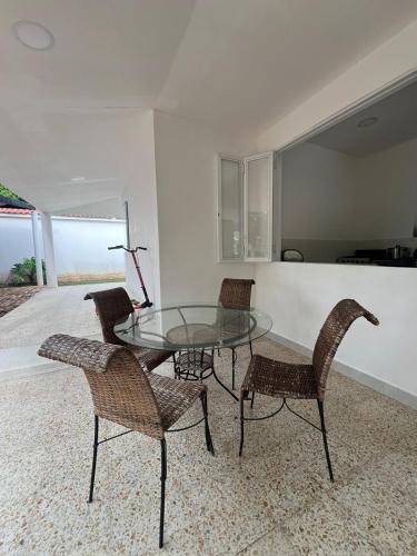 a dining room with a glass table and chairs at Villa Tarek in Carmen de Apicalá