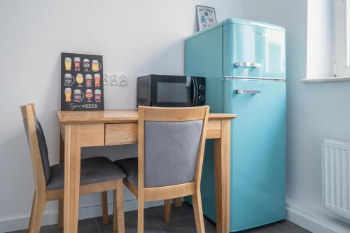 uma cozinha com uma mesa e um frigorífico em Torun Bridge Apartament em Toruń