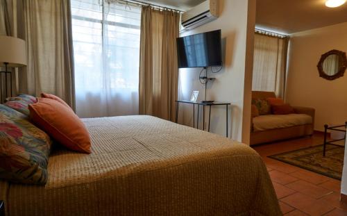 a bedroom with a bed and a flat screen tv at Casa Tlaquepaque in Guadalajara