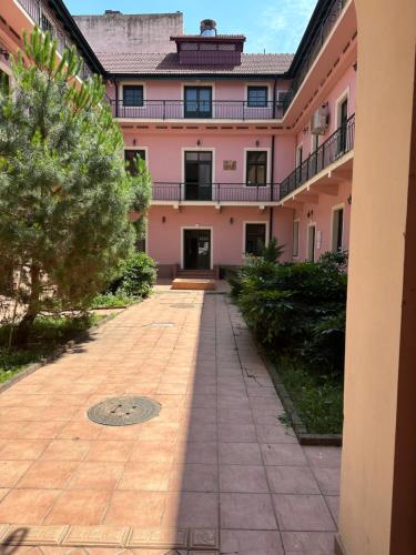 um pátio vazio em frente a um edifício cor-de-rosa em IRIS Le Dome Apartment em Timisoara