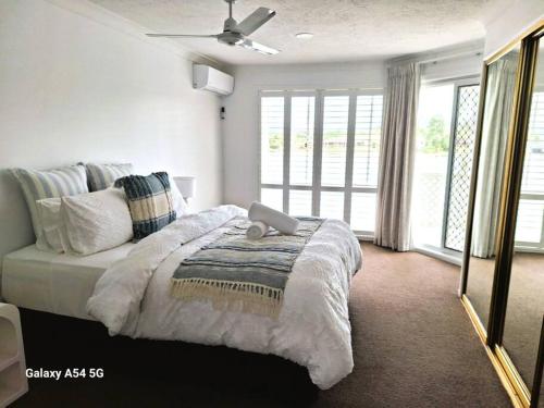 una camera da letto con un grande letto con lenzuola e cuscini bianchi di Isle of Palms 112 a Gold Coast